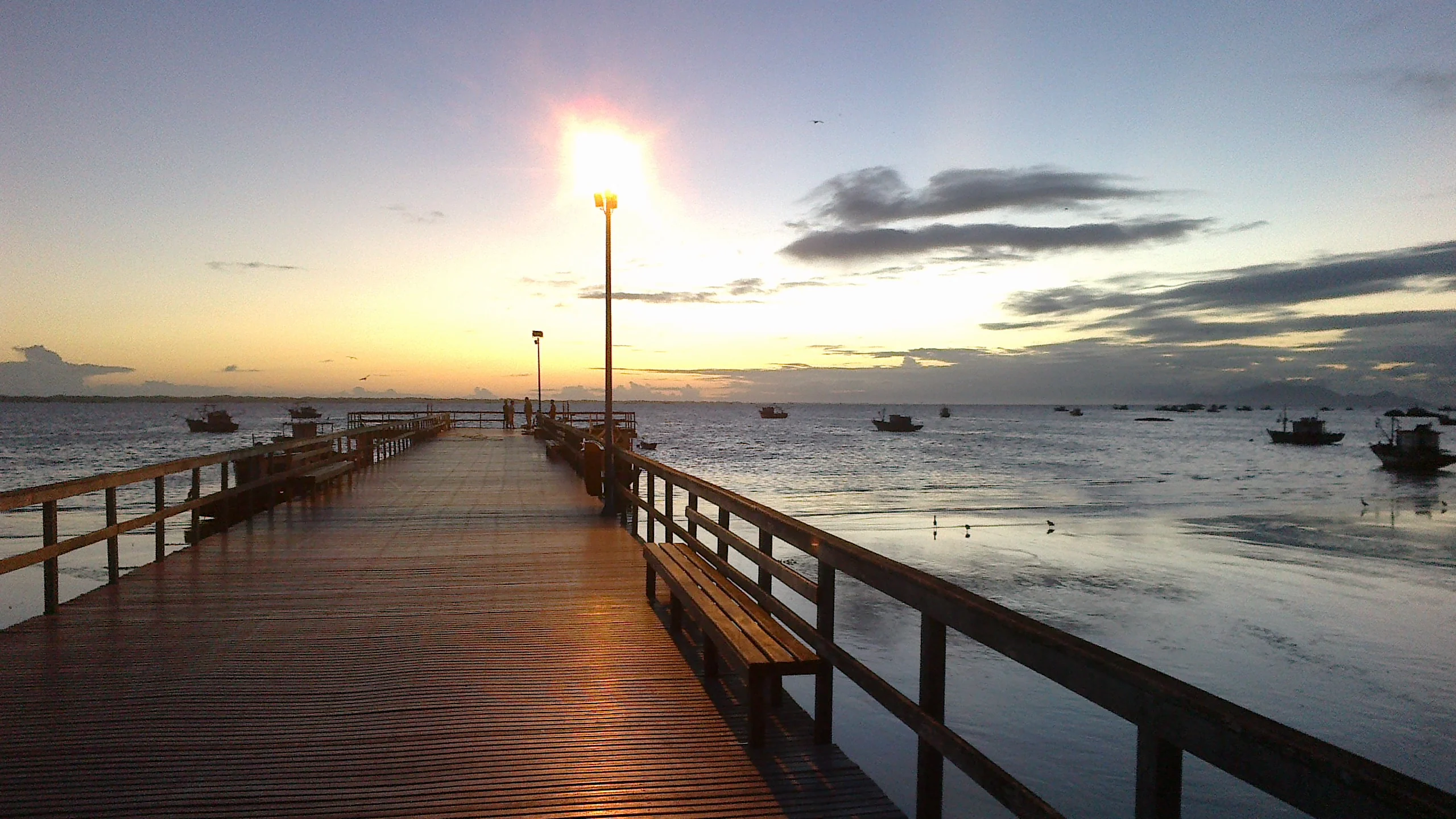 Píer de Pedra de Guaratiba ao entardecer, com barcos na Baía de Sepetiba